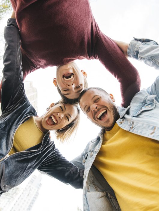 young-multiracial-friends-laughing-standing-circle